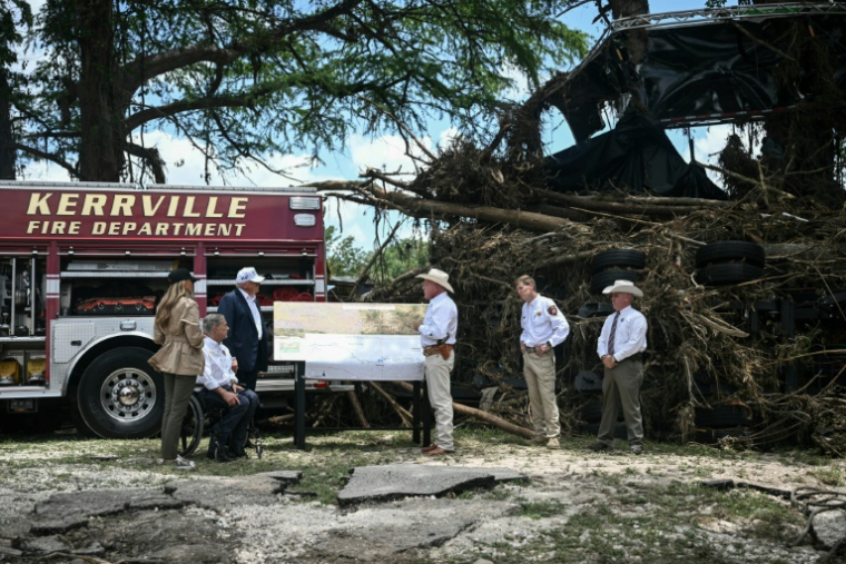 Le président américain Donald Trump, son épouse Melania, et le gouverneur du Texas Greg Abbott rencontre des responsables locaux à Kerrville au Texas, le 11 juillet 2025, sur fond de dégats provoqués par la crue du fleuve Guadaloupe le 4 juillet ( AFP / Brendan SMIALOWSKI )