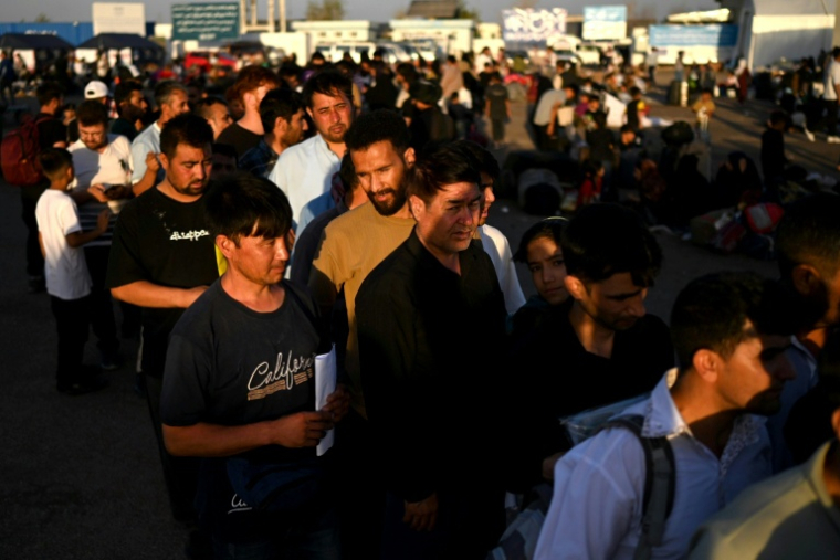 Des réfugiés afghans, expulsés d'Iran, font la queue après leur arrivée au poste-frontière d'Islam Qala, le 28 juin 2025 dans la province de Hérat, en Afghanistan ( AFP / Wakil Kohsar )