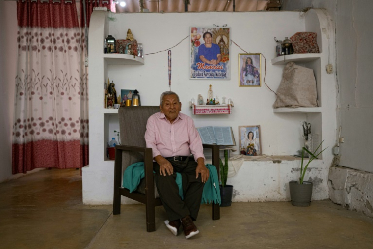 Catalino Puican, 93 ans, pose pour une photo à côté d'un autel dans sa maison d'Eten, dans la région de Lambayeque, au nord du Pérou, le 10 mai 2025 ( AFP / ERNESTO BENAVIDES )