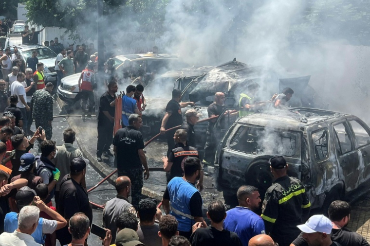 Des secouristes et des habitants sur le site d'une frappe aérienne israélienne qui a touché une voiture à Saïda, le 10 juin 2026 au Liban ( AFP / Mahmoud ZAYYAT )