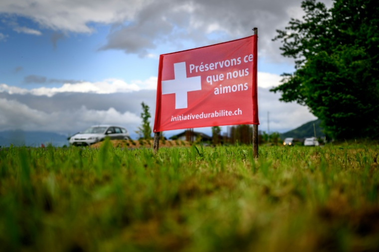 Une banderole électorale portant l'inscription en français éPréservons ce que nous aimons" déployée au bord d'une route à Muraz, avant le vote sur l'initiative d'immigration "Non aux 10 millions", le 10 mai 2026 en Suisse ( AFP / Fabrice COFFRINI )