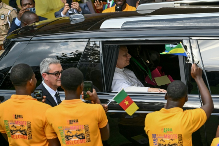 Des étudiants applaudissent l'arrivée du pape Léon XIV (dans la voiture), venu rencontrer étudiants et professeurs de l'Université catholique d'Afrique centrale à Yaoundé, au Cameroun, le 17 avril 2026 ( AFP / Alberto PIZZOLI )