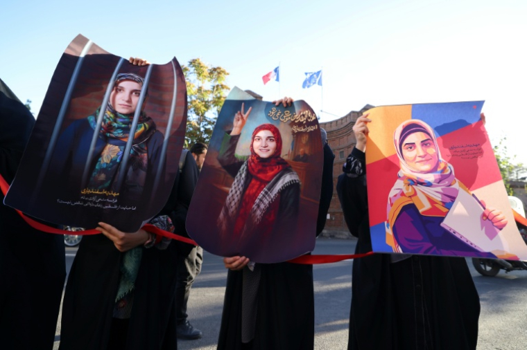 Des portraits de l'Iranienne Mahdieh Esfandiari, arrêtée en France en février 2025, lors d'un rassemblement réclamant sa libération, devant l'ambassade de France à Téhéran, le 21 octobre 2025 ( AFP / ATTA KENARE )
