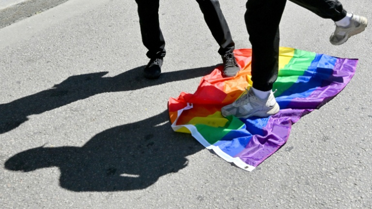 Des manifestants d'extrême droite piétinent le drapeau de la communauté LGBT+ lors d'un contre-rassemblement organisé contre la Marche des Fiertés de Kiev, en Ukraine, le 21 juin 2026 ( AFP / Sergei SUPINSKY )