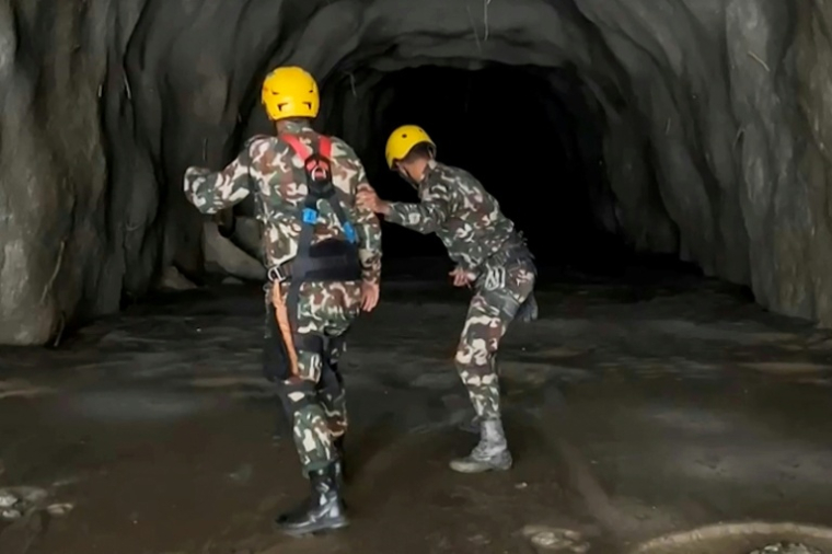 Image tirée d'une vidéo diffusée par le secrétariat du Premier ministre du Népal le 31 août 2026 via l'AFPTV montrant des soldats à l'intérieur d'un tunnel pour secourir des travailleurs, après des crues soudaines sur le site du projet hydroélectrique de Rasuwagadhi, dans le district de Rasuwa, au Népal ( Prime Minister Secretariat, Nepal / HANDOUT )