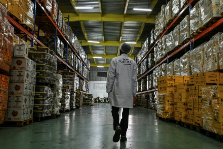 Un employé dans un entrepôt où des palettes de produits cosmétiques  attendent d'être expédiées, à l'usine de fabrication de cosmétiques Kaera dans la zone industrielle de Yopougon, en périphérie d'Abidjan, le 7 juillet 2026 en Côte d'Ivoire ( AFP / Issouf SANOGO )