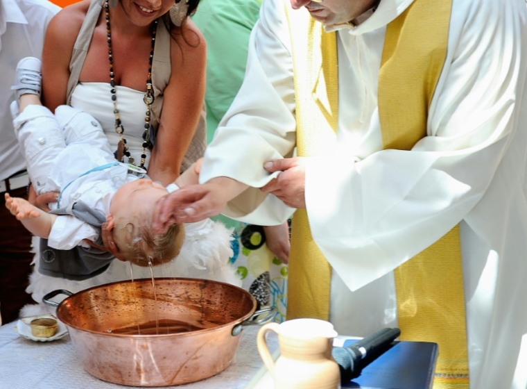 Un prêtre baptise un bébé dans une église de Tourcoing, dans le Nord, le 21 juillet 2013 ( AFP / PHILIPPE HUGUEN )