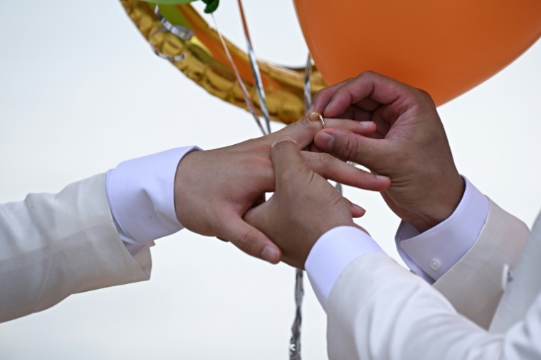 Les Chinois Song Jihan et Wang Zengyi échangent leurs alliances lors de leur mariage près de Pattaya, en Thaïlande, le 31 mai 2025 ( AFP / Lillian SUWANRUMPHA )