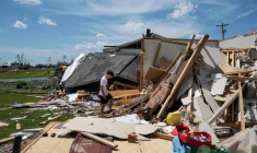 Un jeune garçon marche dans les décombres de sa maison à London, dans le Kentucky, le 17 mai 2025 ( AFP / Allison Joyce )