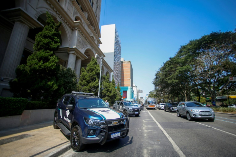 Des véhicules de police devant un immeuble du centre financier de Sao Paulo, au Brésil, pendant une opération contre un réseau de blanchiment d'argent, le 28 août 2025 ( AFP / Miguel SCHINCARIOL )