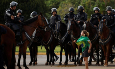 Un manifestant et des membres des forces de sécurité pendant le démantèlement d'un camp de partisans de l'ancien président brésilien Jair Bolsonaro devant le siège de l'armée, à Brasilia