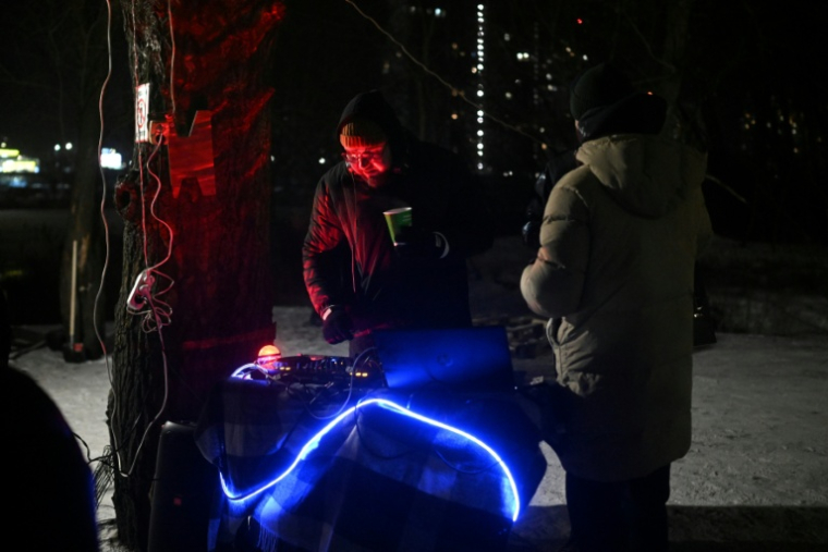 Un DJ anime une fête improvisée par des habitants dans le froid polaire à Kiev, le 18 janvier 2026 ( AFP / Sergei GAPON )