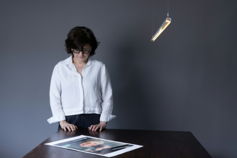 La cinéaste iranienne Sepideh Farsi regarde un portrait de la photographe palestinienne Fatima Hassouna, à son domicile à Paris, le 5 mai 2025 ( AFP / JOEL SAGET )