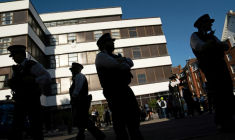Des policiers devant l'hôtel Thistle Barbican à Londres, qui héberge des demandeurs d'asile, le 8 août 2025, avant des manifestations de l'extrême droite ( AFP / Niklas HALLE'N )