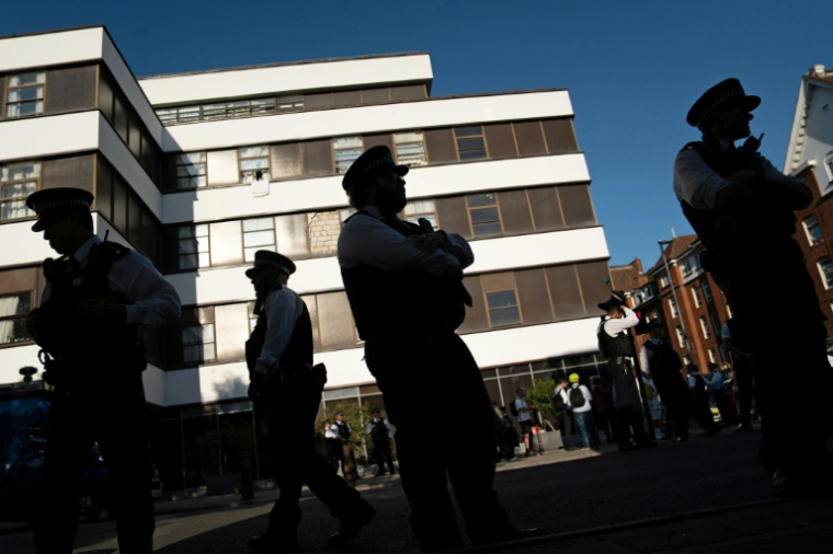 Des policiers devant l'hôtel Thistle Barbican à Londres, qui héberge des demandeurs d'asile, le 8 août 2025, avant des manifestations de l'extrême droite ( AFP / Niklas HALLE'N )
