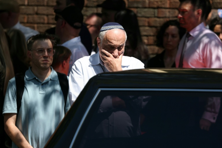 Un homme ému regarde le corbillard après les funérailles de Boris et Sofia Gurman, tués lors de la fusillade de la plage de Bondi, à la Chevra Kadisha de Sydney, le 19 décembre 2025 ( AFP / DAVID GRAY )