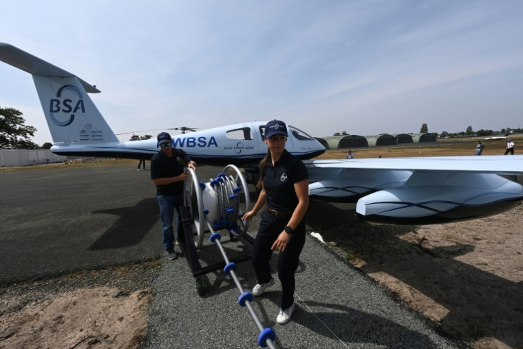 Des employés de Blue Spirit Aero ravitaillent en hydrogène le petit avion Dragonfly sur le tarmac de l'aéroport du Mans, le 10 juin 2025 dans la Sarthe ( AFP / JEAN-FRANCOIS MONIER )