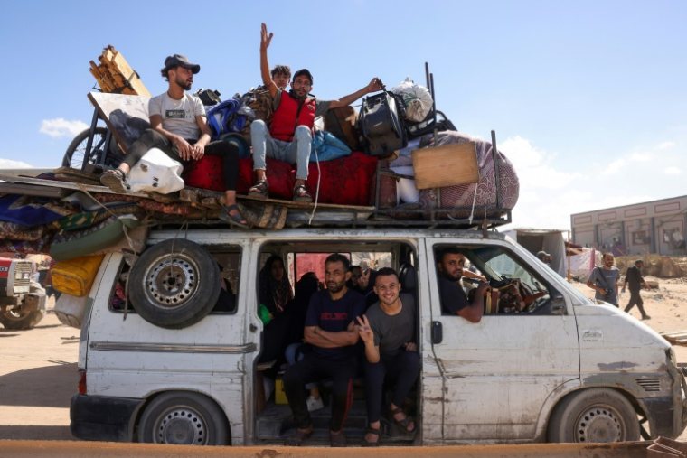 Des Palestiniens transportant leurs effets personnels traversent une route côtière au nord-ouest de Nousseirat (centre) après leur fuite de Gaza-ville, le 1er octobre 2025 ( AFP / Bashar TALEB )