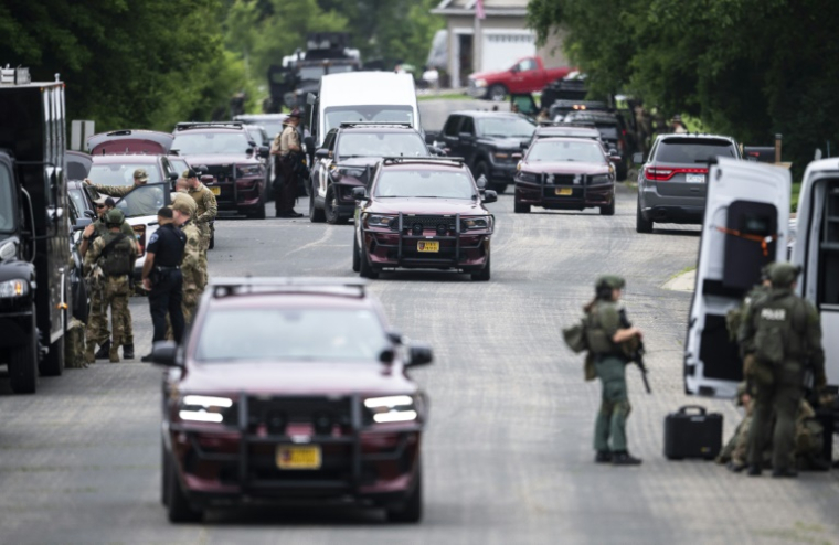Des membres des forces de l'ordre dans un quartier de Green Isle à la recherche du suspect dans le meurtre de l'élue Melissa Hortman et de son mari tués à la veille à leur domicile, le 15 juin 2025 dans le Minnesota ( Getty / Stephen Maturen )
