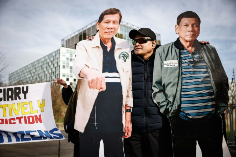 Deux silhouettes en carton grandeur nature de l'ancien président philippin Rodrigo Duterte lors d'une manifestation de soutien devant la Cour pénale internationale (CPI) à La Haye, le 23 février 2026 ( AFP / Simon Wohlfahrt )