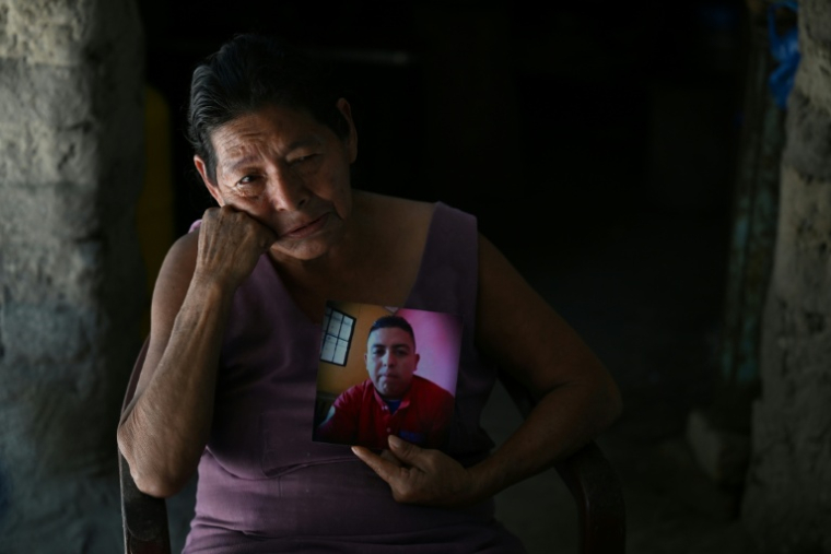 Ana Mercedes Garcia, 63 ans, tient une photo de son fils Ricardo Ernesto Martinez, 31 ans, emprisonné depuis le 10 mai 2022 sous l'état d'urgence promu par le président Nayib Bukele, à Cuyultitán, au Salvador, le 20 août 2025 ( AFP / STRINGER )