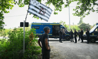 Des gendarmes et des opposants au projet de l'autoroute A69 Toulouse-Castres près de l'entrée du camp où doit se tenir un rassemblement près de Maurens-Scopont, dans le Tarn, le 5 juillet 2025  ( AFP / Matthieu RONDEL )