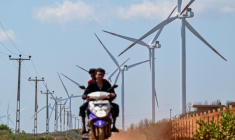 Cette photo, prise le 2 octobre 2026, montre un motard passant devant des éoliennes installées le long d'une route de la péninsule de Mannar, au Sri Lanka ( AFP / Ishara S. KODIKARA )