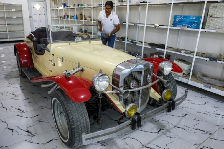 Le collectionneur Jaafar Salmane à côté d'une Mercedes Benz de 1932 restaurée, dans son magasin de pièces détachées à Alexandrie, dans la province de Babel, le 27 mai 2025 en Irak ( AFP / Karar Jabbar )