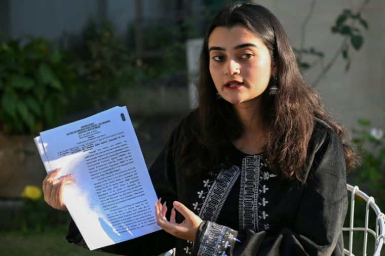 Hania Imran, militante pour le climat, tient une copie de la plainte qu'elle a déposée contre l'État en décembre 2024 pour le "droit de respirer un air pur", lors d'un entretien avec l'AFP à Islamabad, le 14 janvier 2026 au Pakistan ( AFP / Farooq NAEEM )