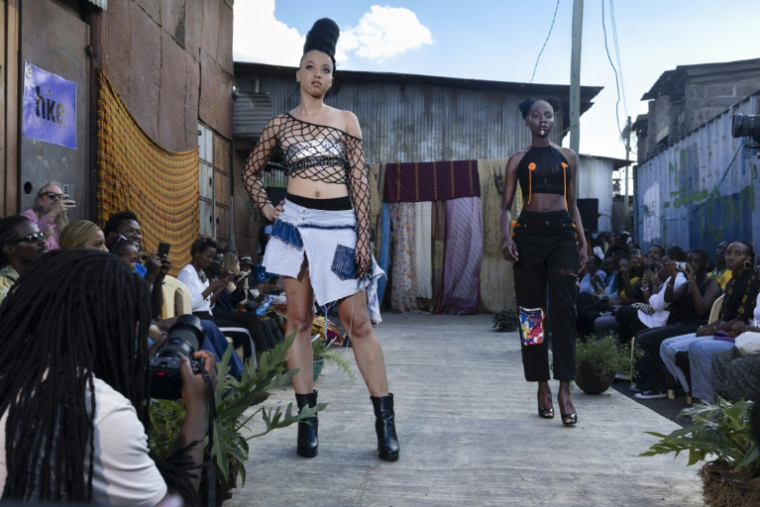 Des mannequins présentent des tenues de créateurs locaux spécialisés dans le recyclage de tissus et de vêtements mis au rebut, lors du défilé de mode Gikomba Runway Edition à Nairobi, le 10 octobre 2025 au Kenya ( AFP / Tony KARUMBA )