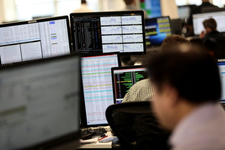 Des traders travaillent en salle des marchés d'IG Index
