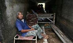 Le fermier thaïlandais Boonkerd Yudeerum est assis dans un bunker avec sa famille dans la province de Surin le 10 décembre 2025, lors d'affrontements le long de la frontière thaïlando-cambodgienne ( AFP / Lillian SUWANRUMPHA )