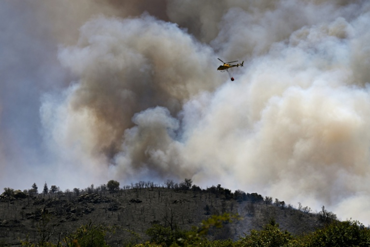 L’hélicoptère H125 de lutte contre l’incendie du SDIS11 (Service départemental d’incendie et de secours) largue de l’eau sur un feu de forêt près du col des Auzines, à proximité de Trévillach, dans le sud de la France, le 5 juillet 2026 ( AFP / Matthieu RONDEL )