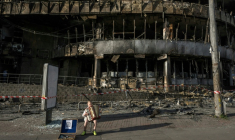 Un garçon joue de l'accordéon devant un centre commercial détruit par des frappes russes à Kiev, le 25 mai 2026 ( AFP / Vladyslav Musiienko )