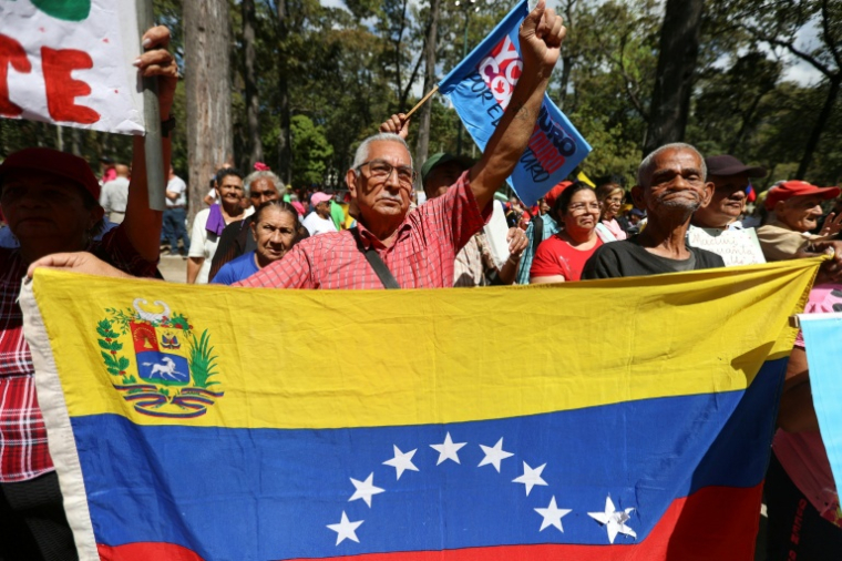 des manifestants brandissent un drapeau vénézuélien lors d'un rassemblement organisé par des personnes âgées pour réclamer la libération du président déchu Nicolas Maduro et de son épouse Cilia Flores, à Caracas, le 21 janvier 2026 ( AFP / Pedro MATTEY )