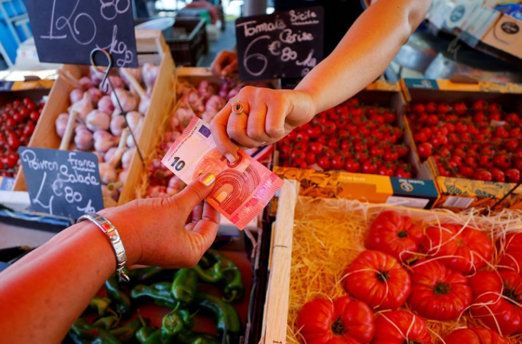 Photo d'archives d'un acheteur qui paie avec un billet de dix euros au marché local à Nice