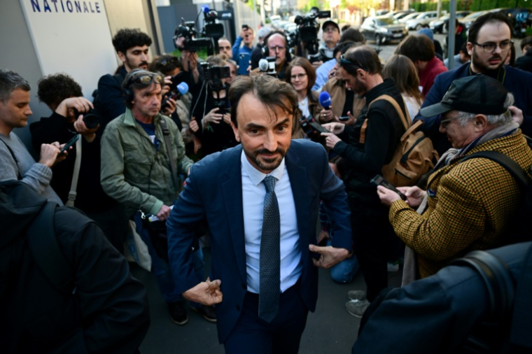 Le maire de Lyon, Grégory Doucet (C), sort après avoir été remis en liberté après plus de 10 heures d'interrogatoire dans le cadre d'une enquête pour détournement de fonds publics, à la préfecture de police de Lyon, le 9 avril 2025 ( AFP / Olivier CHASSIGNOLE )