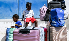 Des enfants de migrants près de valises avant leur retour par vol dans leur pays en Afrique subsaharienne, à Tunis le 16 juin 2026. ( AFP / FETHI BELAID )