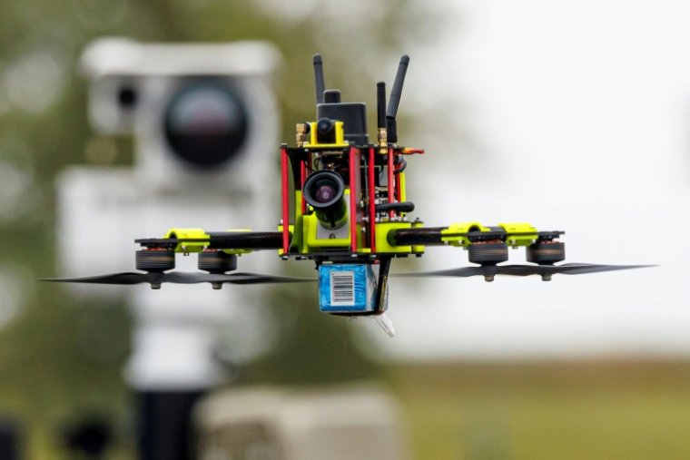 Un drone "chasseur" devant une unité de capteurs mobiles pour la détection de drones au Centre national de test pour les systèmes aériens sans pilote du Centre aérospatial allemand (DLR), lors d'une présentation du programme "Custodian" à Cochstedt, en Allemagne, le 8 octobre 2025 ( AFP / JENS SCHLUETER )