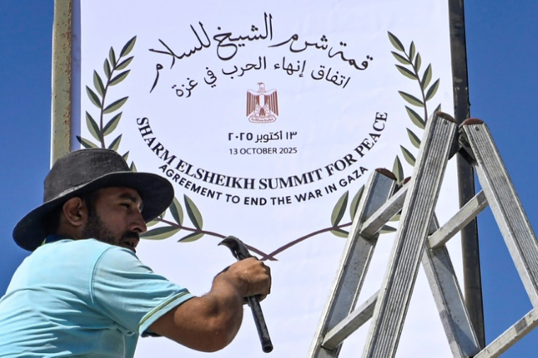 Un employé municipal installe un panneau à Charm el-Cheikh, dans l'est de l'Egypte, qui se prépare à accueillir un "sommet pour la paix" à Gaza parrainé par les Etats-Unis, le 12 octobre 2025 ( AFP / Khaled DESOUKI )