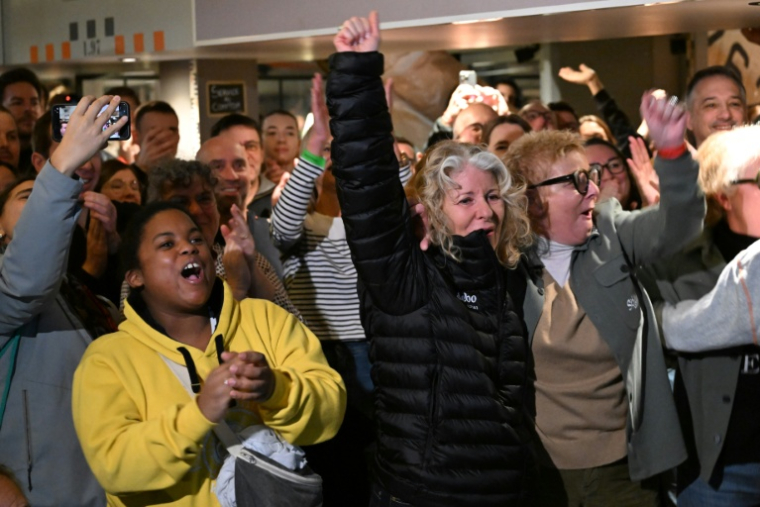 Les proches et supporters de Thomas Coville exultent lorsque le trimaran Sodebo Ultim franchit la ligne du record du tour du monde à la voile (Trophée Jules Verne) dimanche matin à Brest. ( AFP / Sebastien Salom-Gomis )