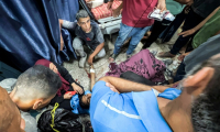 Des Palestiniens entourent l'une des personnes blessées en attendant de l'aide humanitaire près du point de passage de Zikim, dans le nord de la bande de Gaza, le 30 juillet 2025 ( AFP / Bashar TALEB )