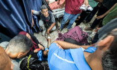 Des Palestiniens entourent l'une des personnes blessées en attendant de l'aide humanitaire près du point de passage de Zikim, dans le nord de la bande de Gaza, le 30 juillet 2025 ( AFP / Bashar TALEB )