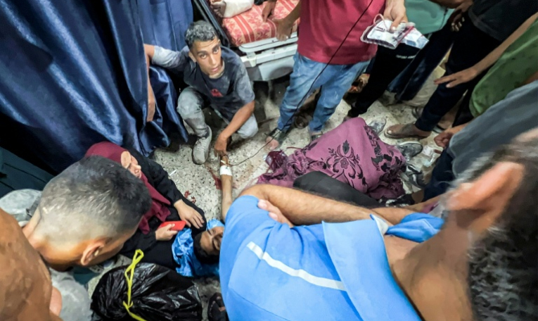 Des Palestiniens entourent l'une des personnes blessées en attendant de l'aide humanitaire près du point de passage de Zikim, dans le nord de la bande de Gaza, le 30 juillet 2025 ( AFP / Bashar TALEB )