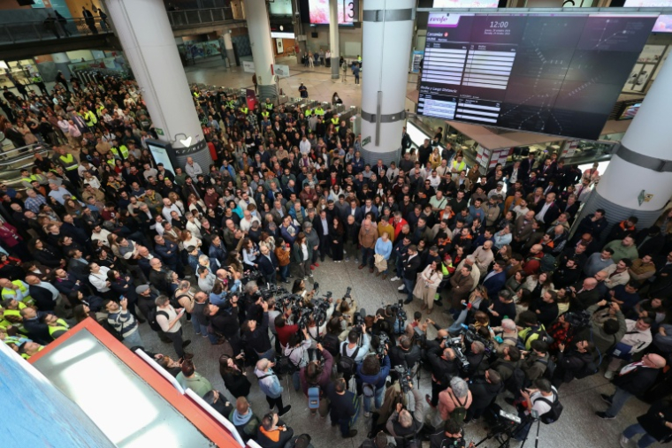 Des voyageurs observent une minute de silence à la gare Atocha à Madrid, en hommage aux victimes de la collision entre deux trains à grande vitesse, le 29 octobre 2026 en Espagne ( AFP / Thomas COEX )