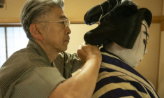 Le maître perruquier Tadashi Kamoji (g) aide l'acteur Tanenosuke Nakamura à mettre sa perruque avant une représentation au théâtre Kabuki-za à Tokyo, le 13 avril 2026 ( AFP / Yuichi YAMAZAKI )