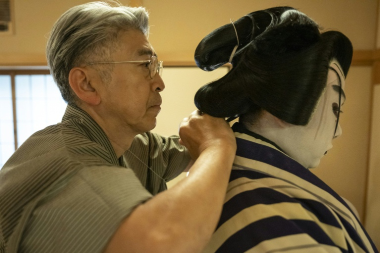 Le maître perruquier Tadashi Kamoji (g) aide l'acteur Tanenosuke Nakamura à mettre sa perruque avant une représentation au théâtre Kabuki-za à Tokyo, le 13 avril 2026 ( AFP / Yuichi YAMAZAKI )