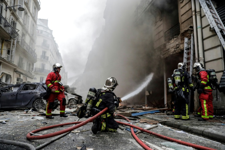 Des pompiers éteignent un incendie à la suite de l'explosion d'une boulangerie, à l'angle des rues Sainte-Cécile et de Trévise, dans le centre de Paris, le 12 janvier 2019 ( AFP / Thomas SAMSON )