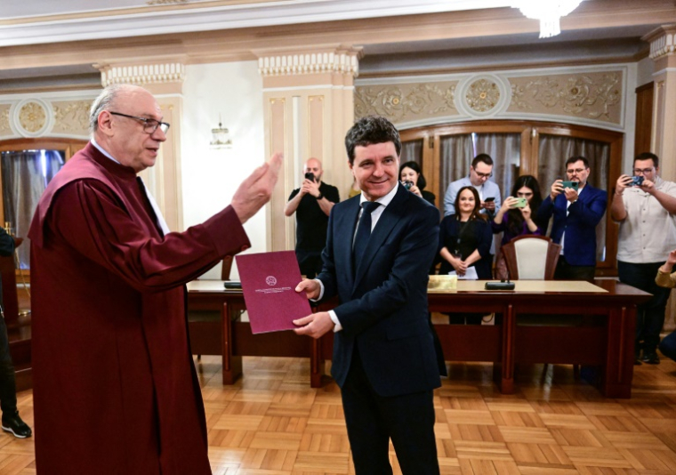 Le nouveau président roumain Nicusor Dan reçoit son mandat du président de la Cour constitutionnelle de Roumanie Marian Enache, au Palais du Parlement à Bucarest, le 22 mai 2025 ( AFP / DANIEL MIHAILESCU )