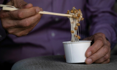 Yoshihiro Noro, propriétaire de l'usine de production de  kamakurayama natto, mélange un natto dans son magasin de Kamakura, à une cinquantaine de km au sud-ouest de Tokyo, le 15 mai 2026  ( AFP / Andrew CABALLERO-REYNOLDS )